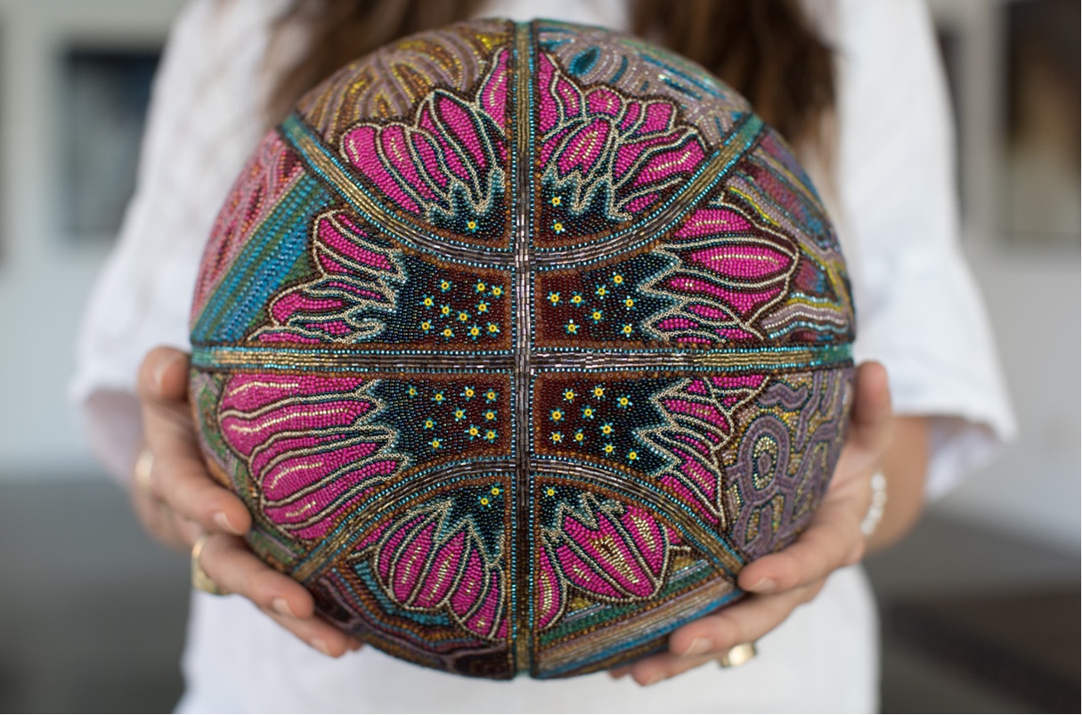 hands hold a beaded basketball