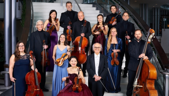 A group of musicians pose together. They are dressed in evening gowns.