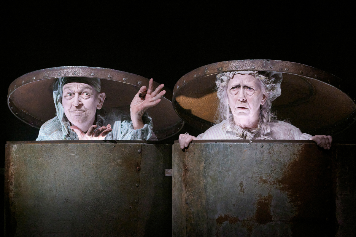 A man and a woman popping out of garbage cans