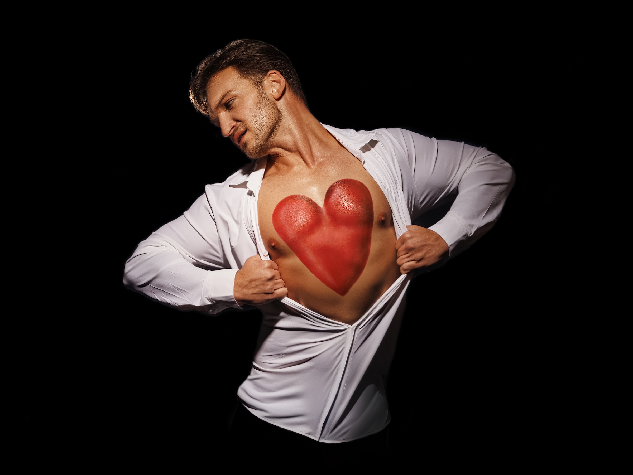 Daniel McGrew rips open his white button-up shirt, revealing a red painted heart on his chest.