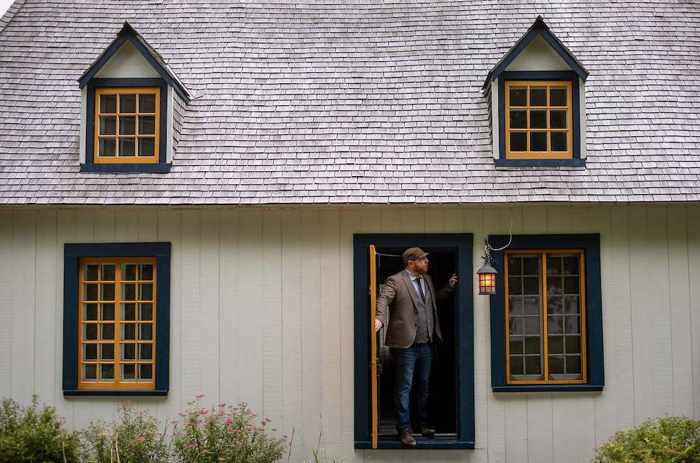 Man standing in doorway opening door outwards
