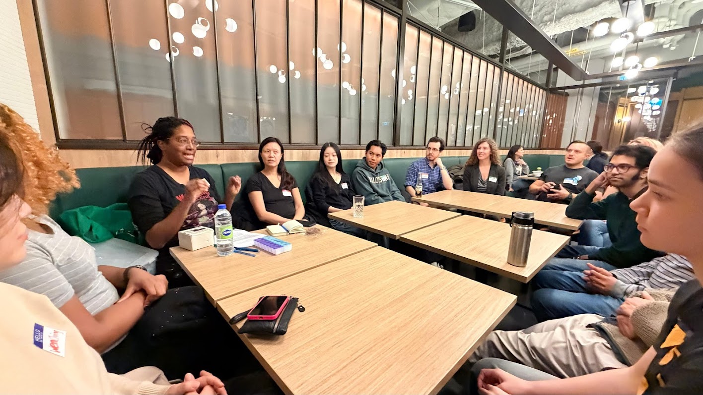 People focus on one lady as she explains the instructions in a circle.