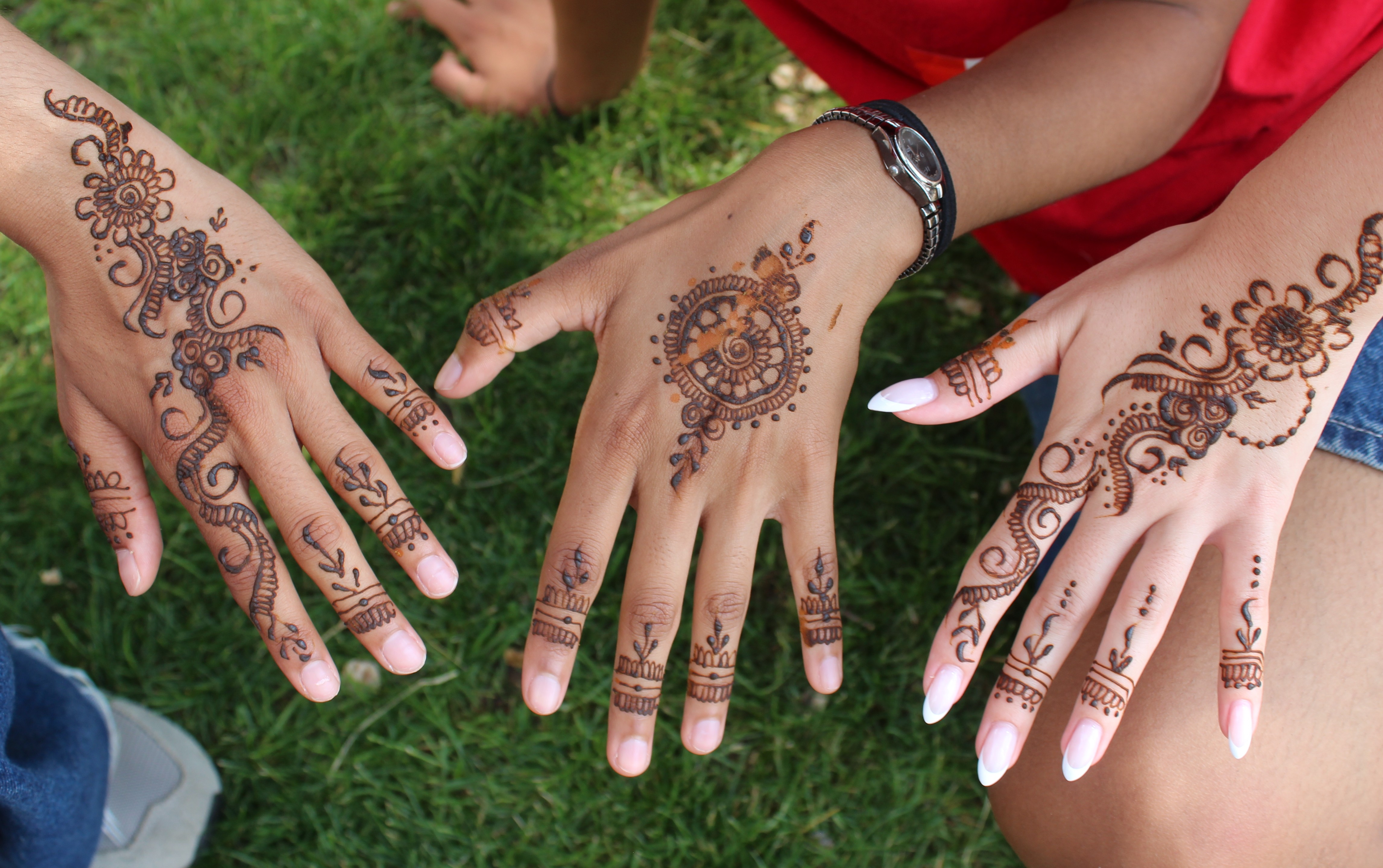 image of three hands with henna
