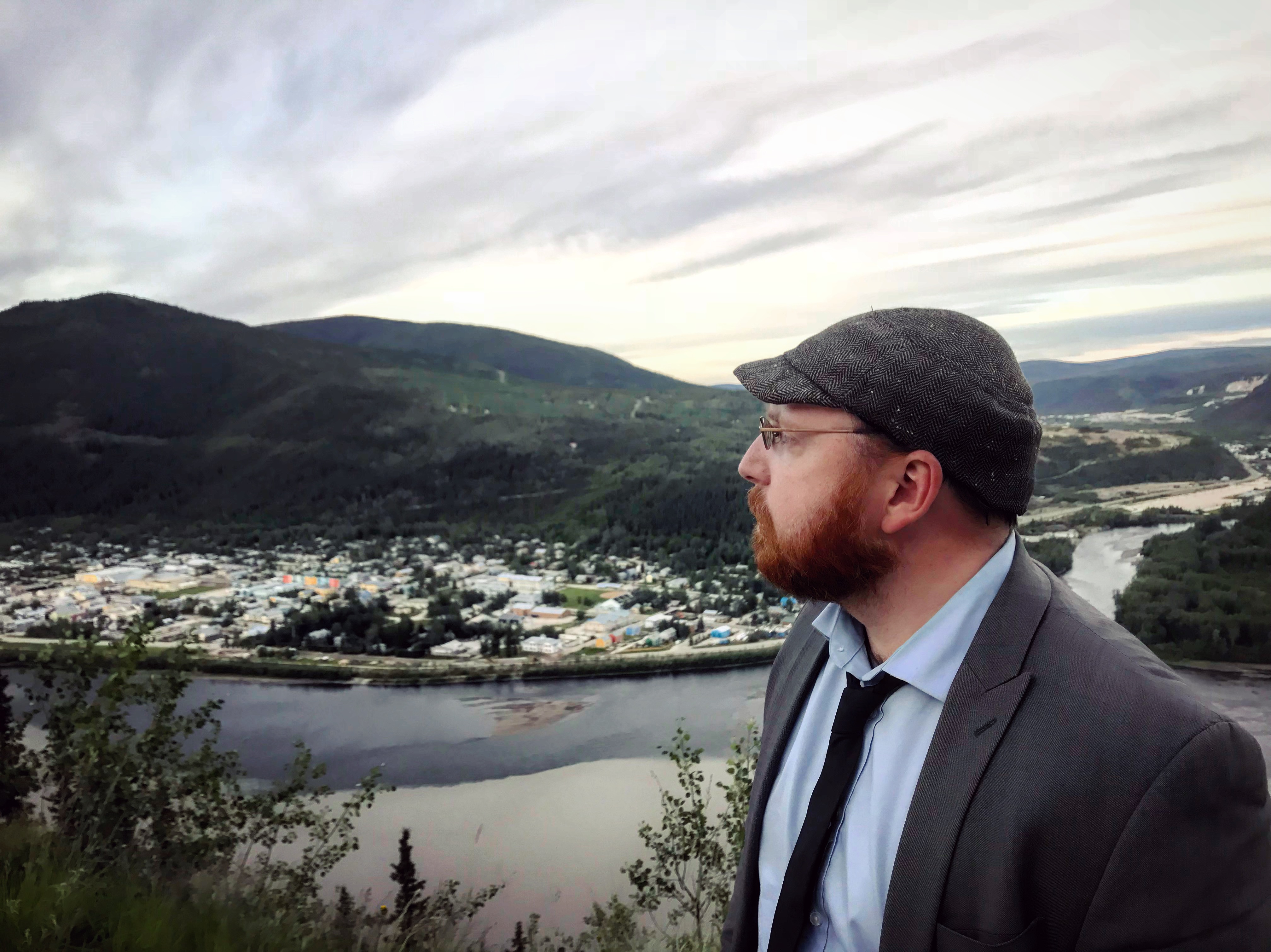 Man standing in profile looking over river