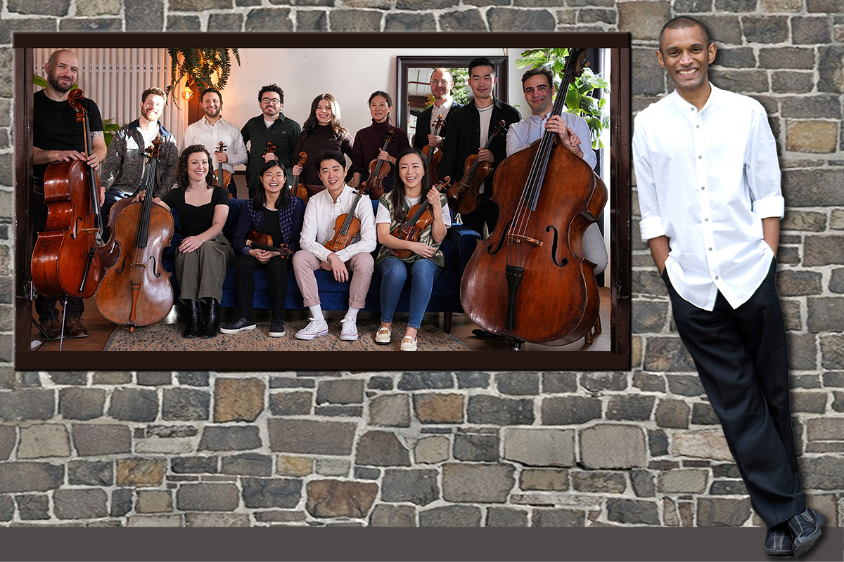 Tall, smiling man in a white shirt and a group of 13 musicians with classical instruments