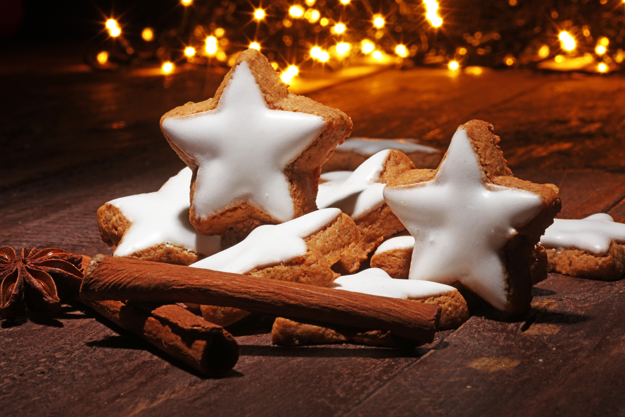 Iced star shaped gingerbread cookies with twinkling lights in the background