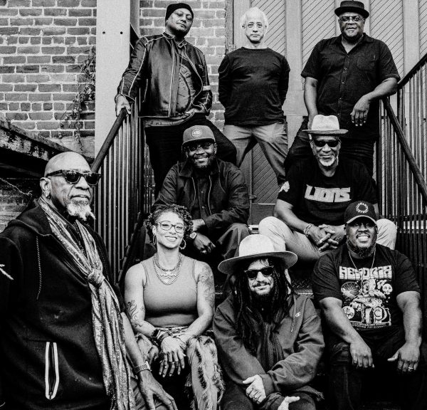 The band sits on an apartment stoop together.