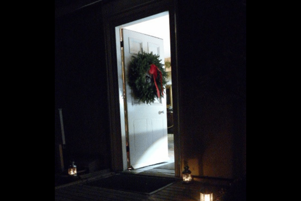 A door on a dark night with a welcoming wreath
