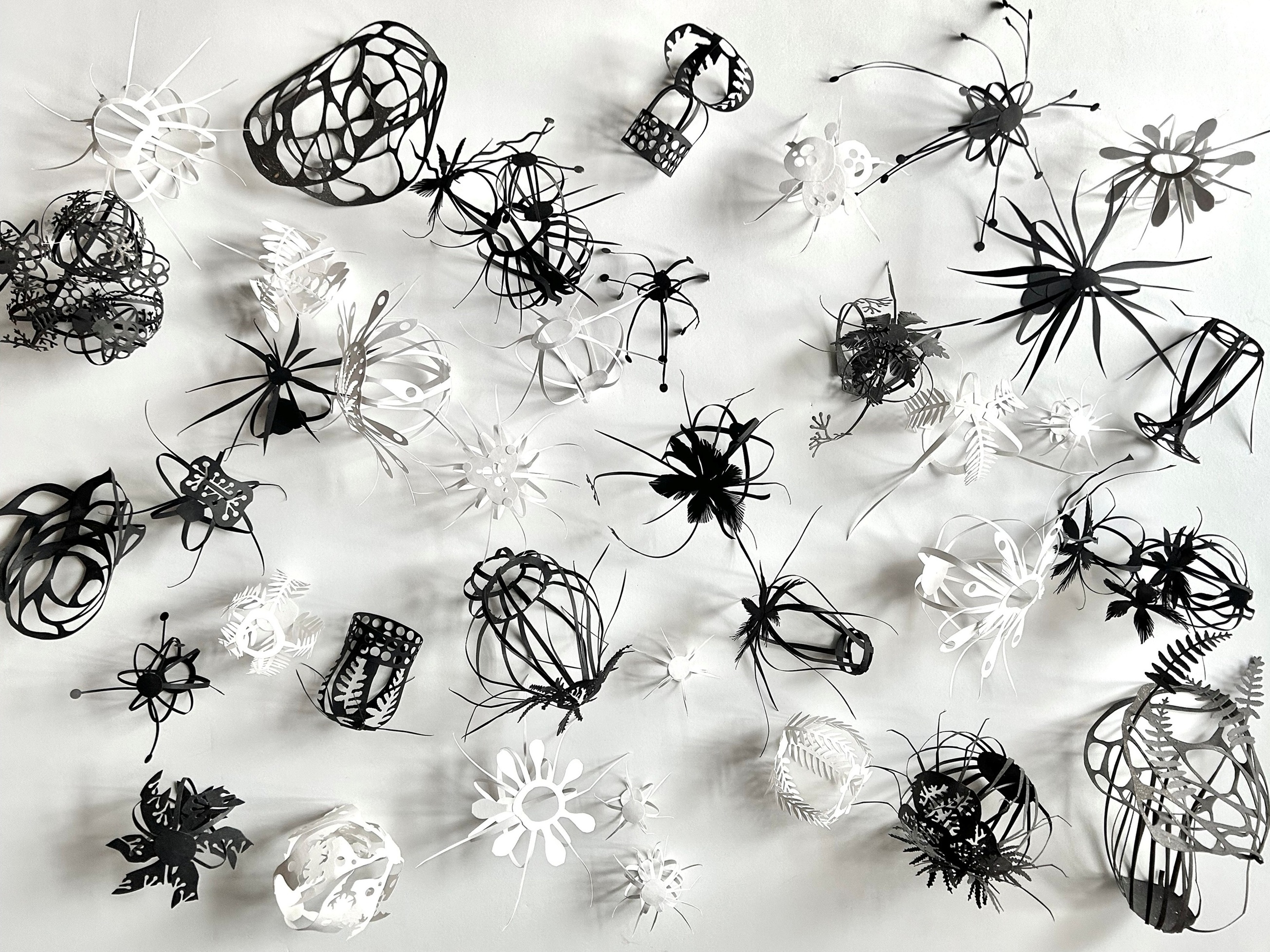 small black and white paper cut sculptures