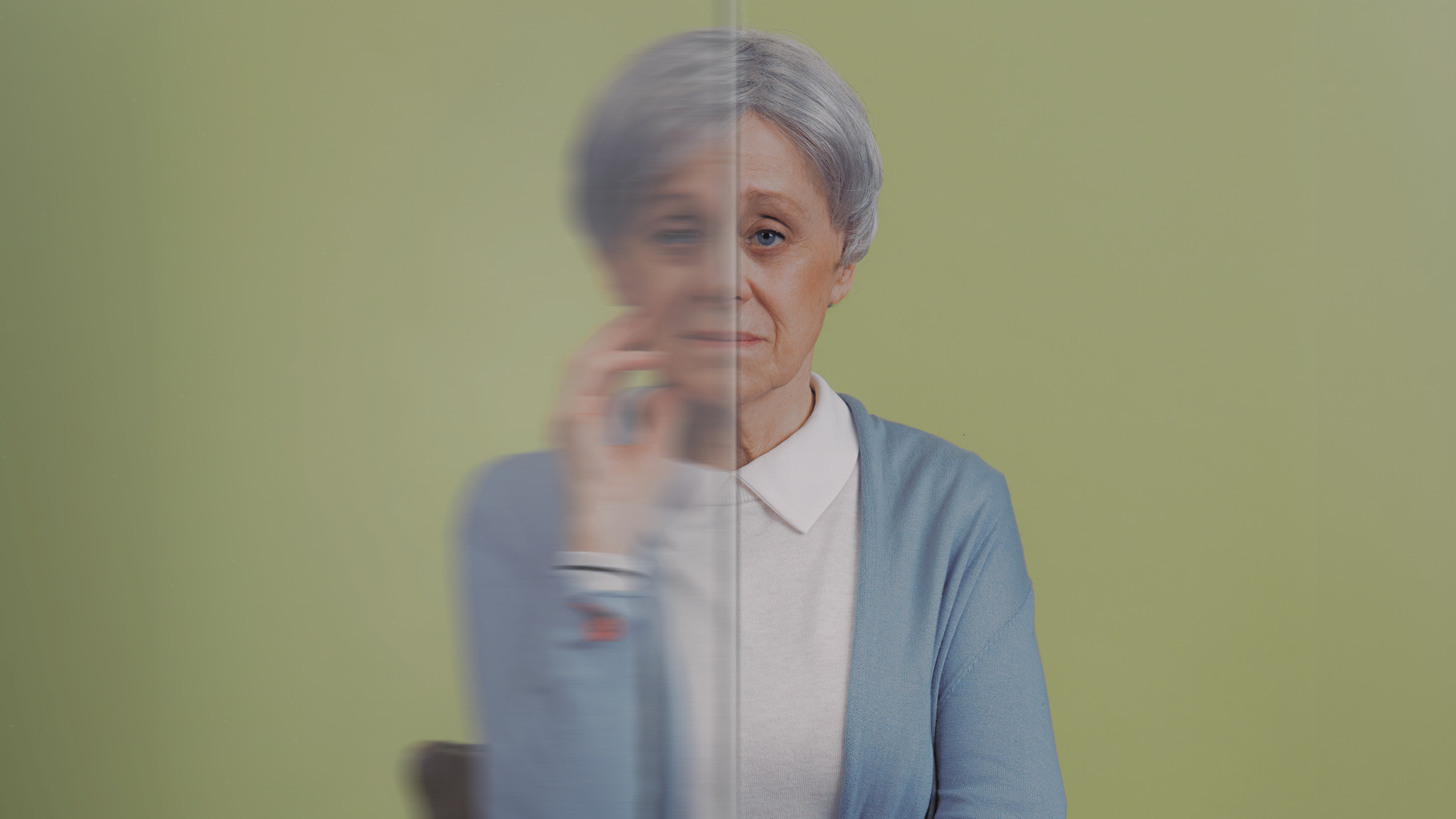 An elderly white woman poses with her hand on her face