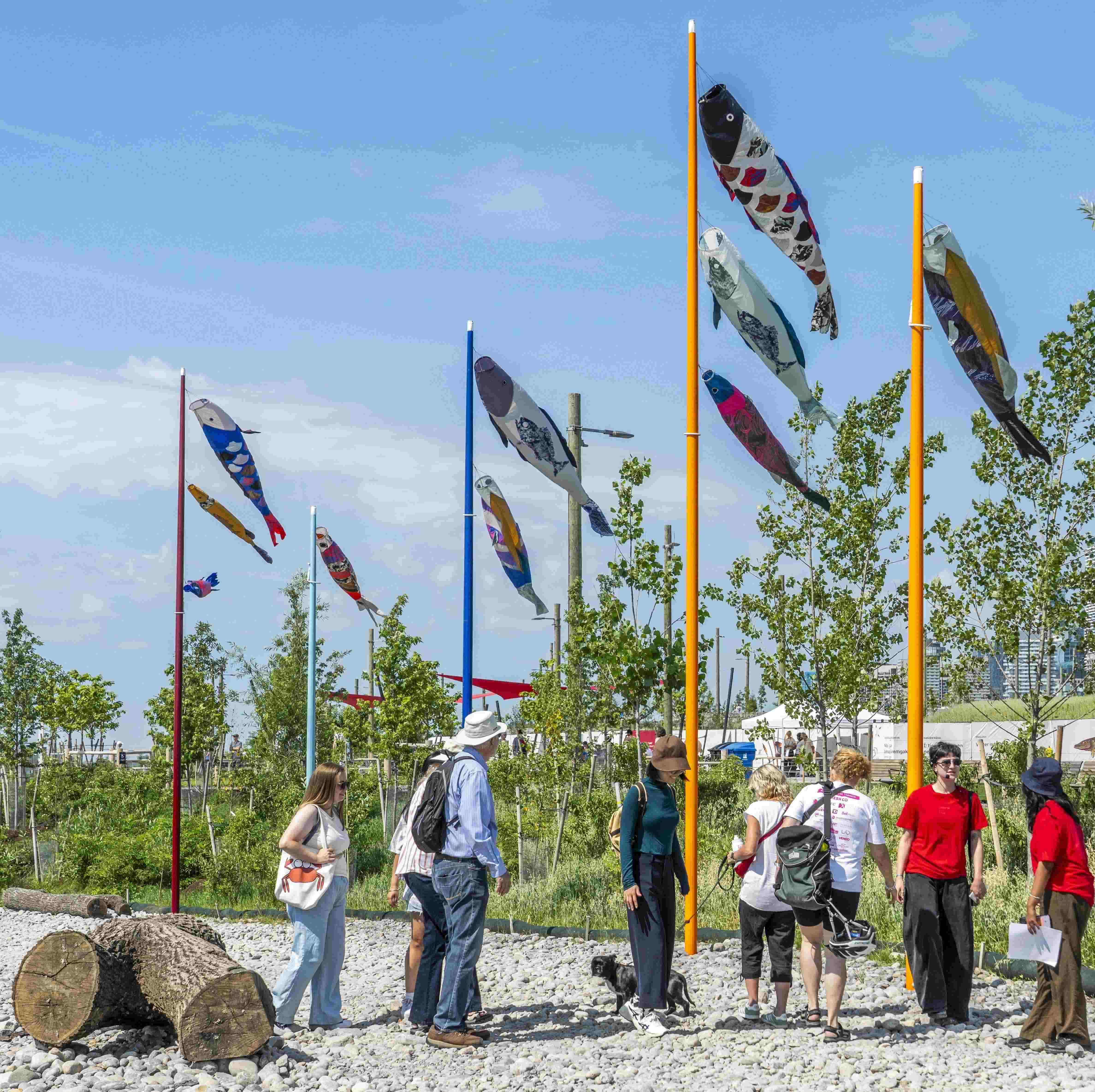 A tour group gathered by Alexa Kumiko Hatanaka’s sculpture against the wind, with the wind
