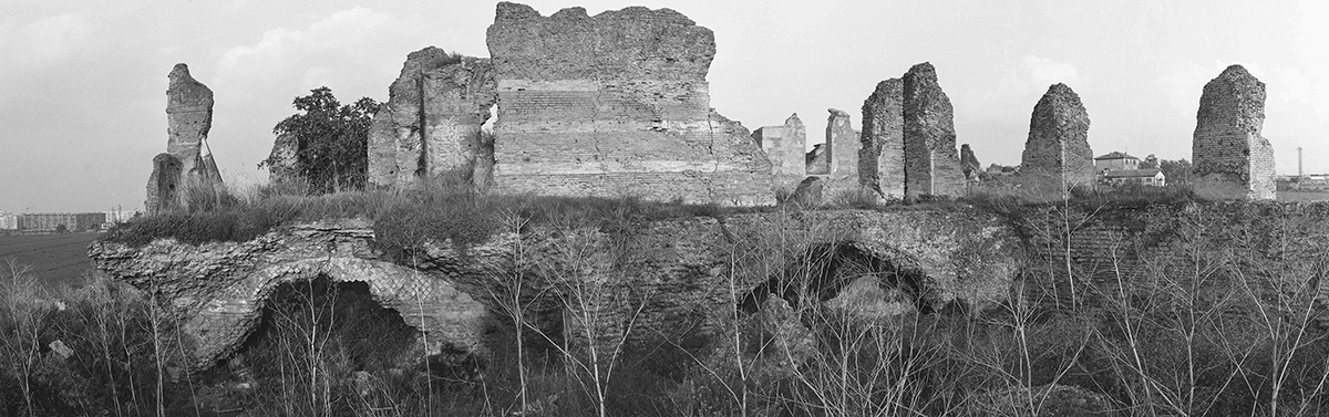 A black and white photograph of the ruins of an Italian aqueduct