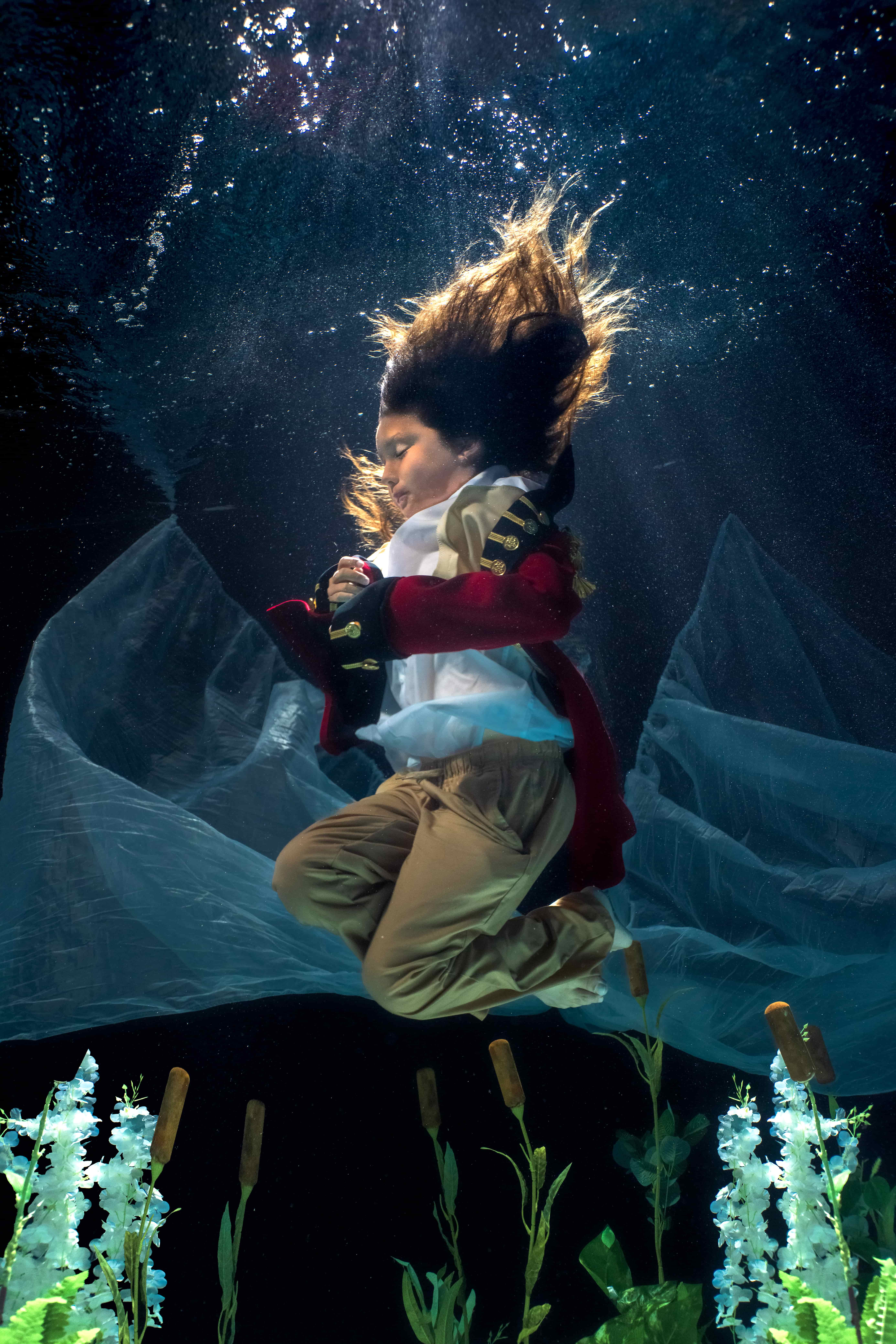 An actor in a red costume underwater