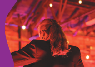 Backshot of a female conductor with her hair in a ponytail.