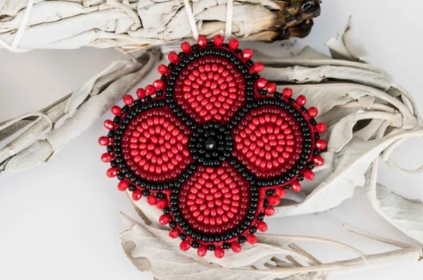 An Indigenous beaded red and black poppy