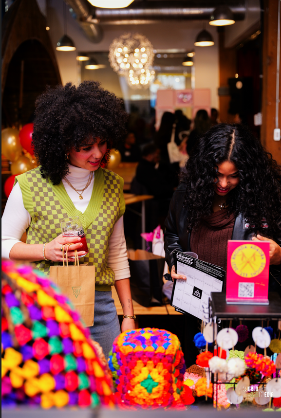 Two Women Shopping At A Local Vendor Market with Bright Colourful Crochet Fashion Items