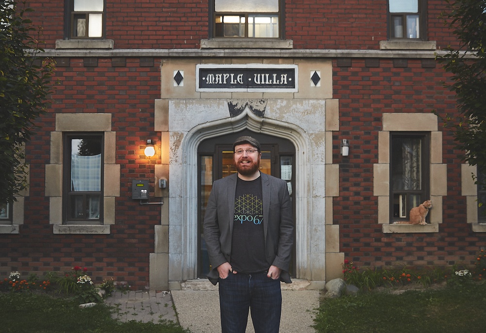 Man standing outside red brick building
